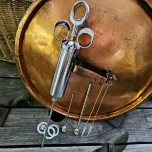 Saltspruta Marinadinjektor Marinadspruta - rostfri injektor med tre nålar för kött och fågel Saltspruta Marinadinjektor Marinadspruta - En mycket rejäl Saltspruta eller som du så vill - marinadinjektor / marinadspruta. Ett välbyggt proffsinstrument som tar din kryddning till en ny nivå. Tillverkat i rostfritt stål, kommer med tre olika nålar (hela 15cm långa) samt extra silikonpackningar som reservdelar. Tack vare tre olika nålar ökar användningsområdena. Nålen med många små hål sprider salt och sockerlösningar snyggt utan en massa hål. Nålen med det grövre hålet fungerar för att injicera grövre lösningar med exempelvis krossade pepparkorn och chiliflakes, den allra finaste nålen lämnar mindre ingångshål efter sig och passar utmärkt när köttstycket är lite tunnare.