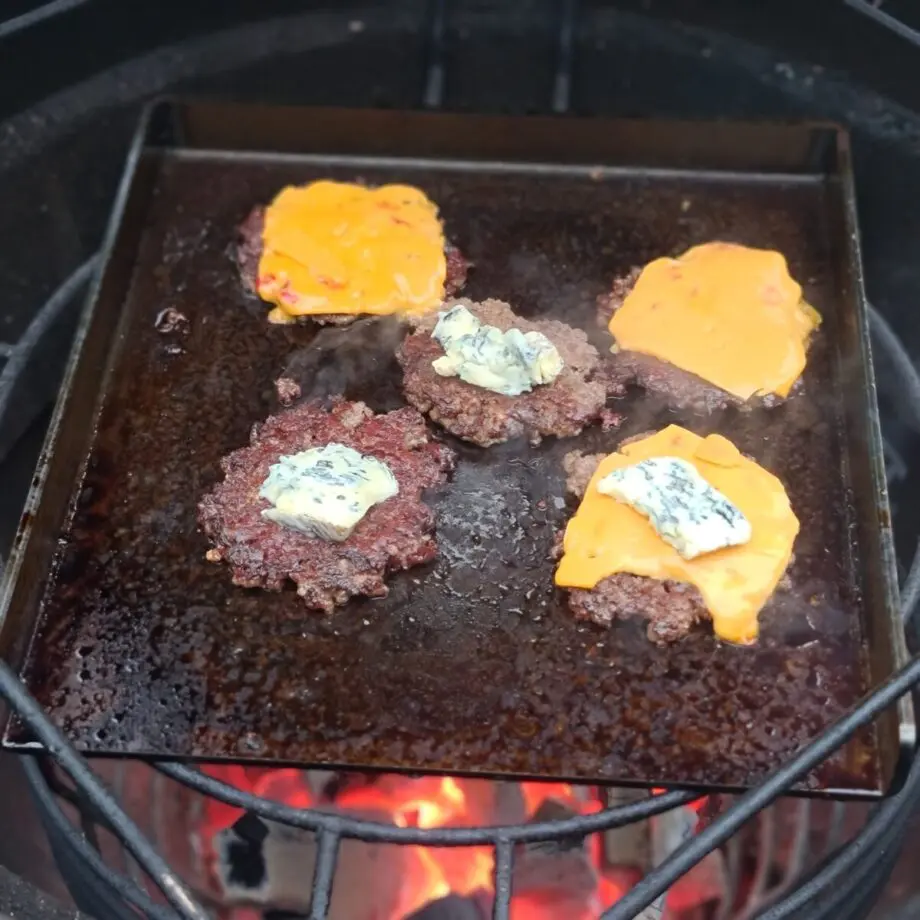 Stekbord / BBQmonster - 5,5 kg kolstål perfekt för smash burgers - för 47cm grillar / kamados och uppåt Detta stekbord i kolstål passar perfekt i Kamados och grillar i storlek 47cm och uppåt.  Storleken gör att det kan cirkulera tillräckligt med luft runt och lämpar sig även för klassiska klotgrillar (likt 57:an). Lägg till BBQmonsters rostfria Smasher och du har ett smash burger kit som kommer ge dig många goa smashade burgare! BBQMonster tröttnade på upputsade (för hur länge är ett stekbord skinande rent?) och snuskigt dyra stekbord och kontaktade ett lokalt företag och bad om ett stekbord i kolstål som levde upp till följande kriterier: Kolstål - för bästa värmeledningsförmåga Maximerad storlek för en 47cm kamado (kamado joe classic, BGE large mfl) Kraftigt stål för att kunna få vätska att avdunsta snabbt Kanter på tre av sidorna för att fånga fett och underlätta flippandet En inbränd logo för att visa var det kommer ifrån Ut från "smen" kom ett hundratal produkter och där stekbordet i sig vägde in sig på en stabil matchvikt runt 5.5kg och måtten 34cm x 32 cm med en 4cm hög kant och ett gods som är 6mm tjockt. More is more Ju grövre gods desto mer energi kan lagras i metallen. När du lägger på en bit kött kommer energi (värme) stjälas från godset. Är godset för tunt blir det snabbt kallt och du får inte den önskade karamelliserade ytan utan köttets yta blir snarare lätt kokt under en kort tid. Grovt kolstål likt detta kan ackumulera mycket värme och ger ett högre värmeanslag mot livsmedlet detta oavsett om vi pratar om ett stekbord eller stekpanna i gjutjärn. Smash burgers Smashburgers är inte längre en trend utan är numera standard för att göra fina burgare på bra färs. För att lyckas med en fin smashad burgare så behöver du bra färs, gärna av högrev, gärna av grainfed blackangus, och en fetthalt som närmar sig 20% (det finns såklart i butiken ;)). Därefter behöver du en värmekälla som ger dig runt 300 grader (BBQMonster rekommenderar kolen av Björk/EK) samt ett stekbord likt detta. Salta och peppra färsen när du försiktigt lagt ut den som en två cm tjock matta. Tryck med dina rena (!) fingertoppar ner salt och svartpeppar i färsen, detta utan att förstöra "köttsträngarna".  Forma ut bollar i en vikt som motsvarar den storlek du önskar på burgarna, många gör hellre fler små burgare än en feting (då får man mer av den goda smått brända utsidan!).  Låt stekbordet vara med över kolen redan från början när du tänder, då blir det ordentligt uppvärmt och du minskar risken för att stålet slår sig. När tempen passerar 300 grader så tar du fram dina bollar (rätt bollar) och lägger dem på stekbordet. Börja med en, när det fräst och bubblat ut lite fett från bollen så tar du fram din "smasher" och ger köttet ett jämnt och lagom hårt tryck för att pressa ut köttbollen till en burgare i den tjocklek du önskar. Lägg på nästa boll och pressa ut den, repetera. Eftersom att du har köpt en väldigt bra färs så kommer burgaren att gå att vända väldigt enkelt med hjälp av en klassisk turner. Vänd burgarna i samma ordning som du la på dem på stekbordet. Grattis - du har nu smashat dina första burgare och du kommer aldrig återgå till någon annan tillagningsform.