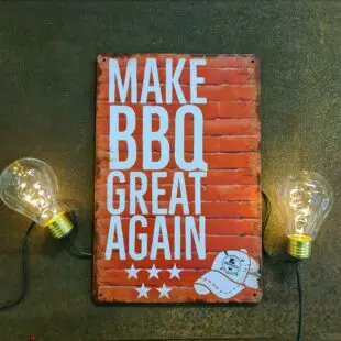 Plåtskylt för kök mm. "Make BBQ great again" Skylt för kök, utekök, grillhörna, BBQ, Bar, Mancave Dekorera din favoritplats med skyltar och metalltavlor i rustik vintage design som bjuder in till ett skratt eller två ;) Här plåtskylten som förkunnar det som vi alla vet måste komma - Make BBQ great again. Tavlor i metall och plåtskyltar? BBQmonster har en häftig samling tavlor och skyltar i metall som kan vara den perfekta presenten eller tillbehöret till presenten som gör pricken över i:et, eller "the prick over the eye" som man säger i Amerikat... Metalltavlor för grill och BBQ är efterfrågade dekorer till utekök, mancaves och grillhörnor och med BBQmonsters uppsättning är chansen god att du hittar en skylt som passar just dig eller den person du skall köpa presenten till. Ett presenttips kan vara att om du köper låt säga ett paket spanska ginglas att då komplettera med en skylt som förstärker budskapet. Samma sak kan appliceras Ölglas, Kamados osv. Livsnjutare, Foodies och grillare är ofta glada för både god mat och god dryck. Därför kretsar många av dessa vintage skyltar och metalltavlor på tema Mat, såsom recepttavlor (för exempelvis Pulled pork, Revben / Ribs och Brisket). Eller Dryck (whisky, bourbon, beer, öl, IPA, Cider, Stout och inte minst modedrycken GIN). Tavlorna i metall finns i ett antal olika format, men där det vanligaste är måtten 20 x 30 (stående) cm eller 30 x 20 (liggande). Det finns även ett par större modeller (bland annat runda). Skyltarna har en vikt kant så inga vassa kanter existerar. Hörnen är försedda med hål (på det fyrkantiga tavlorna) där du enkelt med två eller fyra spik eller skruvar fäster upp tavlan på underlaget. Du kan även använda dubbelhäftande tejp om det passar bättre mot underlaget. Du hittar alla tavlor och skyltar under kategorin Tavlor metall (www.bbqmonster.se/produkt-kategori/tavlor/)