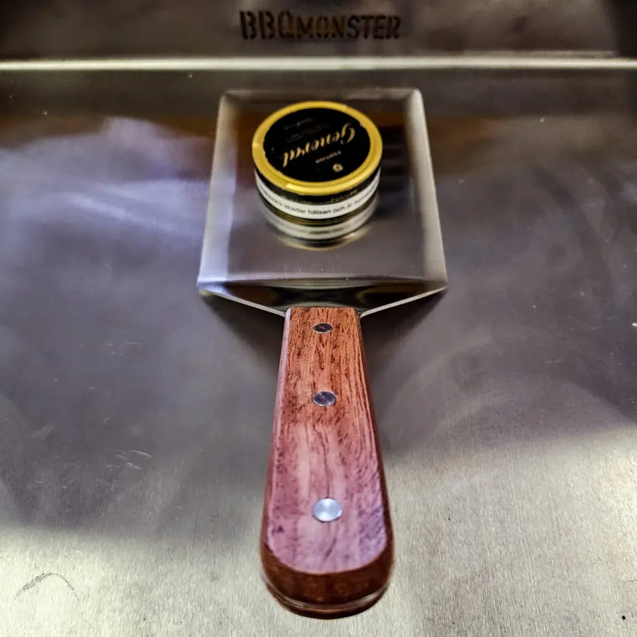 Hamburgerspade BBQmonster  - Stor och tung XXL Spatula för Grill och Stekbord 13x16cm plan yta med facettslipade kanter för bättre kontakt Detta är en hamburgerspade, grillspade, även kallat Spatula i XXL storlek. Med en vikt på runt halvkilot så är det enkelt att förstå att vi pratar om rejäla doningar och ingen "spackel-spade".  Den användbara ytan är drygt 13cm bred och 16cm lång. Kanterna har en fasadslipad kant vilket gör att du enkelt kan lägga an kanten hela vägen ned mot stekbordet. Denna spade som är gjord i rostfritt stål uppfyller alla krav som kan ställas på en bra hamburgerspade och har dessutom ett bekvämt och tjockt grepp av trä. 