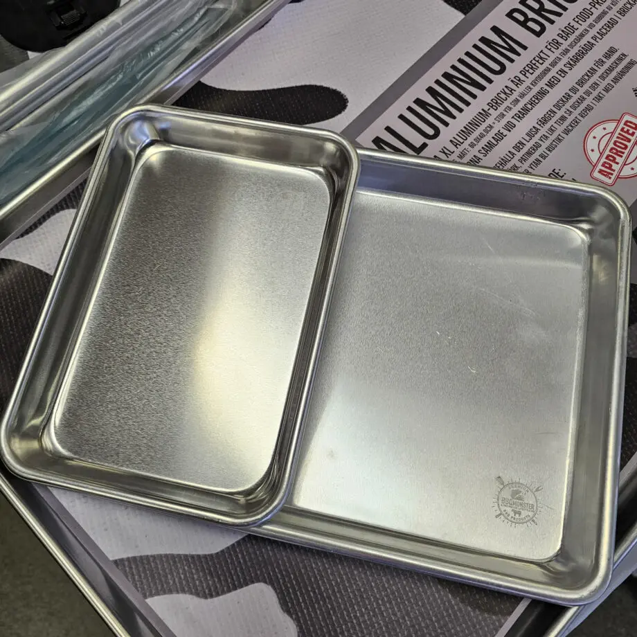 Mini BBQ Tallrik Aluminium Plate 24*16*2,6cm Bricka - metalltallrik för servering - perfekt för burgare - Två stycken av denna ryms i den en storlek större alu-tallriken En ruggigt robust "mini" BBQ Alu tallrik - en kvalitet som du inte sett innan! BBQmonster skulle vilja påstå att detta är marknadens mest stabila och robusta BBQ tallrik, som också passar perfekt som serveringsbricka för exempelvis burgare. Brickan har BBQmonsters logo diskret lasergraverad i ena hörnet. BBQmonster sätter bara sin sigill på prylar som håller måttet och där det kan sägas med stolthet att det är pryl värdig Foodies och Grillers med krav - denna BBQ Alu bricka är en sådan pryl. Grymt snygg och praktisk "mini-tallrik" i obehandlad Aluminium. Skapar den rustika BBQ, grill och Steakhouse-känslan. Blir bara snyggare med tiden med de repor som uppkommer vid användning. Komplettera med några snygga grillknivar och du har en riktigt cool dukning inom räckhåll. Tålig och enkel att rengöra. Fungerar även perfekt som uppläggningsfat och smidigt när du rubbar en mindre köttbit. Tips: Vill du behålla den i blank aluminium-finish så handdiskar du den, vill du den skall få ett utseende likt "tenn" så kör du den i diskmaskin upprepade gånger (obs - den går efter det ej att "återställa" till originalskick). Vill du göra rengöringen ännu enklare och dukningen ännu mer cool så lägger du slaktarpapper som underlag. Mått: 24cm * 16,5 cm  episkt snygg hygienisk och lättrengjord tål upp till 400 grader C Se även de två större brickorna i samma kvalitet: Medium (tallriksmodellen för de flesta) Large (kylskåpsanpassad och passa de flesta ugnar!) XL (perfekt för som underlag vid köttpreparering eller som bricka för att servera från. Om du skall hantera tallriken direkt från Grillen så tänk på att skydda tassarna! https://bbqmonster.se/produkt/grillvantar-bbq-gloves-varmetaliga-handskar/ Se övriga BBQmonster sigillprodukter https://bbqmonster.se/produkt-kategori/bbqmonster-branded-products/