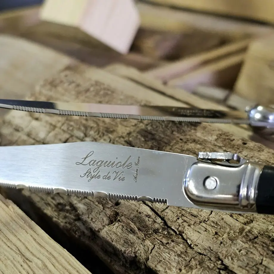 Köttknivar Laguiole dark wood - 6pack köttbestick - eleganta bestick som skär snyggt kommer med vackert knivställ av trä Laguiole Black köttknivar är lika fina att skära med som de är vackra att duka med. Du köper dessa i 6-pack och de kommer med ett vackert förvaringsställ av trä - de kan med andra ord stå framme utan att skämma ut sig. Här har du den perfekta presenten till dig själv eller en annan köttälskare som uppskattar både effektiva knivar att skära med och som gillar den eleganta och tidlösa designen som Laguiole står för. Laguiole Besticken har ett detaljerat och vackert handtag som ligger bra i handen. Handtag och knivblad har samma längd 12cm + 12cm, vilket ger knivarna en perfekt balans. Eggen är mycket fint tandad vilket gör att du utan problem skär fiber för fiber med raka snygga snitt. Dessa köttbestick bör diskas för hand även om de är klassade att tåla maskindisk (dock är maskindiskmedel ofta mer blekande och tärande på material med mycket detaljer - som dessa knivar har). I förpackningen ingår: 6 stycken eleganta Laguiole köttknivar 1 styck knivställ / knivblock i trä