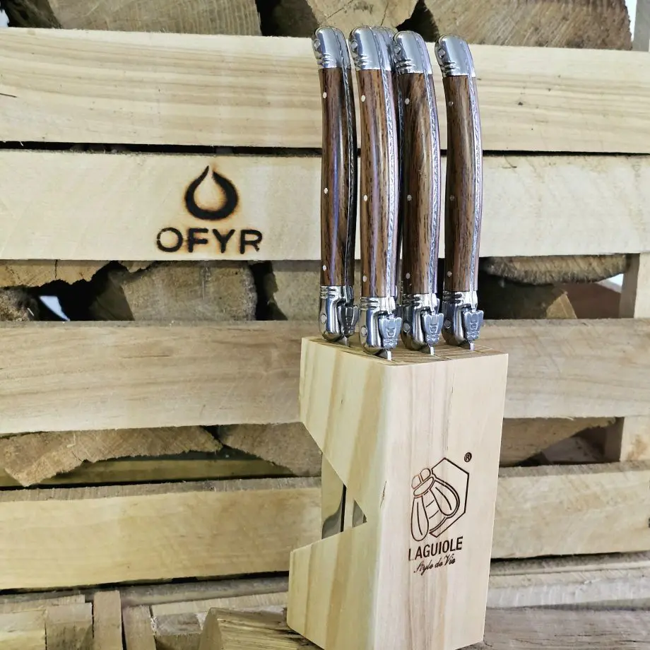 Köttknivar Laguiole Wood - 6pack köttbestick - eleganta bestick som skär snyggt kommer med vackert knivställ av trä Laguiole Wood köttknivar är lika fina att skära med som de är vackra att duka med. Du köper dessa i 6-pack och de kommer med ett vackert förvaringsställ av trä - de kan med andra ord stå framme utan att skämma ut sig. Här har du den perfekta presenten till dig själv eller en annan köttälskare som uppskattar både effektiva knivar att skära med och som gillar den eleganta och tidlösa designen som Laguiole står för. Laguiole Besticken har ett detaljerat och vackert handtag som ligger bra i handen. Handtag och knivblad har samma längd 12cm + 12cm, vilket ger knivarna en perfekt balans. Eggen är mycket fint tandad vilket gör att du utan problem skär fiber för fiber med raka snygga snitt. Dessa köttbestick bör diskas för hand även om de är klassade att tåla maskindisk (dock är maskindiskmedel ofta mer blekande och tärande på material med mycket detaljer - som dessa knivar har). I förpackningen ingår: 6 stycken eleganta Laguiole köttknivar 1 styck knivställ / knivblock i trä