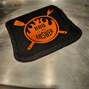 Grillhandskar + Grytlapp deluxe, Grytlapp bäst i test vår uppdaterade design här i kit med en "power mit" perfekt när vi pratar om extremvärme. Silikonprint för enkelt teckenspråk genom fönstret ;) Grillvantar, BBQ gloves, BBQ-handskar, Värmetåliga handskar - kärt barn har många namn och är ett måste för Kamado-ägaren eller den som tröttnat på grilltången för att försöka flytta gallret eller deflektorstenar = grundpackning 1A! Våra Grillhandskar BBQmonster har vi gjort i olika designer sedan starten 2017 och det är ingen lögn när vi skriver att dessa värmetåliga handskar älskas av kunderna. Inte bara rackarens snygga utan också smidiga, bekväma och inte viktigast av allt - värmetålig utsida som tåler upp till 500 grader C. Fodret är mjuk och bekvämt och storleken på handskarna är tilltagna så att du enkelt kan dem av och på utan struligheter. Detta par kommer i ett kit som innehåller två Grillhandskar + Grytlapp som är gjord i samma extremt värmetåliga textil - perfekt när vi pratar om extremvärme som pizzabakning eller stekbord i kolstål som behöver flyttas "in action"