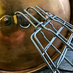 Fiskhalster Grillhalster med krok istället för handtag - passar med locket stängt - rostfritt stål Fiskhalster är ett grillhalster tänkt för hel fisk eller filéer. Fördelen blir enkel vändning utan att fisken går sönder eller bränner fast på gallret. Krok för vertikal rökning avslutar. Halstret ersätter grillnät med fördelen att du slipper teflonliknande material i din matlagning.  BBQmonsters Fiskhalster är konstruerat i formen av en fisk i storlek runt 2kg. Halstret öppnas och stängt enkelt med en ring som låser de båda sidorna. Innehållet i halstret skapa spänningen som krävs för att ringen skall låsa sig fast och utrymmet är naturligt flexibelt och tolererar en tjocklek på mellan 2 och 4 cm. Vill du grilla eller röka fisken så är det praktiskt att halstret inte har ett handtag, på så vis kan du utföra rökningen med stängt lock. Storleken gör att detta fiskhalster passar både i gasolgrillar, Kamado grillar som Kamado Joe classic och klotgrillar (och givetvis större modeller som Big Joe och offset smokers) Finns utrymmet till att hänga in fisken vertikalt är detta möjligt tack vare att halstret avslutas med en krok. För ännu säkrare förankring kan du först hänga in en slaktkrok och sen hänga halstret i denna. Fördelen med hängande rökning av fisk är att du förlänger tiden i rök, då luft leder sämre än galler (som fisken annars ligger på). Testa gärna kallröka lax och öring med en kallrökningsenhet, en spiral du fyller med spån och fjuttar fyr, utan att använda någon annan form av värmekällan.