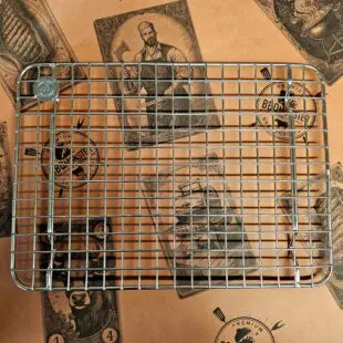 Cooling rack medium - Avsvalningsgaller - 30cm x 22cm - låt köttet vila effektivt på detta galler av rostfritt stål, skräddarsytt för våra egna aluminiumbrickor Cooling rack medium är vårt egna, extremt stabila och välbyggda avsvalningsgaller för storsäljaren BBQ-bricka Medium. Rostfritt stål som håller år ut och år in. Som på alla andra produkter som vi är extra stolta över bär också detta galler vår logo - ett mynt, eller ett logo-coin som vi kallar det, fast-svetsat uppe i en hörnet. Med Cooling rack medium skapar du luft under köttet och processen med att vila ner köttet (ex. brisket eller pulled pork karré) ned mot 70 grader går därmed snabbare.