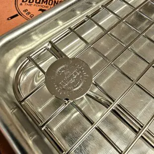 Cooling rack Mini - Avsvalningsgaller - 22cm x 14cm - låt köttet vila effektivt på detta galler av rostfritt stål, skräddarsytt för våra egna aluminiumbrickor Cooling rack Mini är vårt egna, extremt stabila och välbyggda avsvalningsgaller för vår minsta aluminium fast-food-bricka. Rostfritt stål som håller år ut och år in. Som på alla andra produkter som vi är extra stolta över bär också detta galler vår logo - ett mynt, eller ett logo-coin som vi kallar det, fast-svetsat uppe i en hörnet.