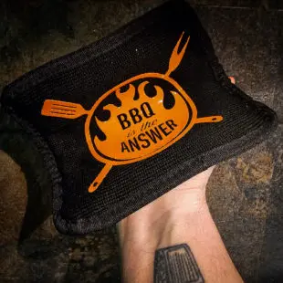 Grillhandskar + Grytlapp deluxe, vår uppdaterade design här i kit med en "power mit" perfekt när vi pratar om extremvärme. Silikonprint för enkelt teckenspråk genom fönstret ;) Grillvantar, BBQ gloves, BBQ-handskar, Värmetåliga handskar - kärt barn har många namn och är ett måste för Kamado-ägaren eller den som tröttnat på grilltången för att försöka flytta gallret eller deflektorstenar = grundpackning 1A! Våra Grillhandskar BBQmonster har vi gjort i olika designer sedan starten 2017 och det är ingen lögn när vi skriver att dessa värmetåliga handskar älskas av kunderna. Inte bara rackarens snygga utan också smidiga, bekväma och inte viktigast av allt - värmetålig utsida som tåler upp till 500 grader C. Fodret är mjuk och bekvämt och storleken på handskarna är tilltagna så att du enkelt kan dem av och på utan struligheter. Detta par kommer i ett kit som innehåller två Grillhandskar + Grytlapp som är gjord i samma extremt värmetåliga textil - perfekt när vi pratar om extremvärme som pizzabakning eller stekbord i kolstål som behöver flyttas "in action"