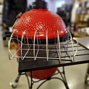 Rib rack Best Revbenshållare för 5 revben Perfekt för st. Louis cut ribs - gott om plats Rib rack Best eller vertikalhållare för revben om du så vill är guds gåva till oss som älskar ribs. Denna modell utnyttjar ytan maximalt i en kamado joe classic och andra 47cm kamados. Givetvis passar den därmed även utmärkt i en större kamado som Kamado Joe Big Joe. Ribs är en mycket tacksam styckdetalj för grillen. Skall det nämnas något negativt kring köttdetaljen så är det att det krävs ganska mycket ben per person, detta då mängden kött per ben är begränsad. Med en hållare som placerar revbenen vertikalt ökar du din grills kapacitet dramatiskt.