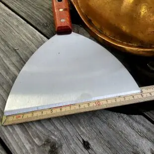 Stekbordsskrapa XL - 50% bredare Snygg och rejäl stekbordsskrapa för kolstål mm. rengör ännu enklare stekbord och stekytor på din grill och i köket Stekbordsskrapa XL- så du kan lägga in spackelspaden i förrådet igen. Perfekt för rengöring av kolstålsstekbord. Bred, stabil, vass och oumbärlig. Stekborsskrapan har en vass egg med en vinkel som gör att den håller sig vass även vid tufft arbete mot hårt underlag såsom kolstål eller gjutjärn. Handtaget är av äkta trä och har snygga nitar i rostfritt samt ett hål för upphängning på en spik eller krok.