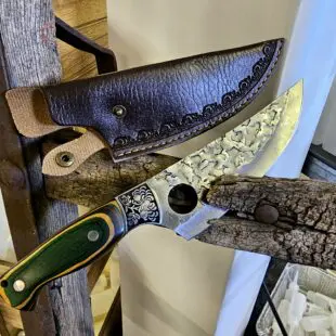 Funktionskniv Asian Trigger 27cm - grovt kolstål med med snyggt hamrat blad och galet vass - plats för pekfingret i bladet för mer kraft Funktionskniv Asian Trigger är en kökskniv av typen som bäst beskrivs som en funktionskniv. Kökskniv Trigger kan användas till det mesta i köket men även en bra kompis på äventyret i vildmarken då en slida är inkluderad.  Att typen av kniv blivit populär beror sannolikt på hålet i bladet som ger dig en naturlig plats att placera ditt pekfinger, detta för mer kraft och bättre känsla att styra kniven även vid precisionsjobb.