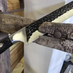 Smidd brisketkniv 43cm Skinkkniv / slicer Trancherkniv för tunna och jämna skivor Smidd brisketkniv 43cm med vackert hamrat stål på bladet vilket gör att skivorna inte limmar sig fast. Fungerar suveränt även som skinkkniv och såklart även för kallrökt lax. Här har du en mycket prisvärd smidd och bankad Brisketkniv 43cm lång, vilket når tvärsöver även en full brisket. Denna brisketkniv har ett lite över medelstyvt blad och såklart en sylvass egg. Den bankade ytan är inte bara vacker utan minskar risken för att det som du skär upp fastnar på bladet.