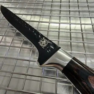 Urbeningskniv / putskniv Total Black - proffsig kniv för att bena ur och putsa kött - sylvass köttkniv för finlir och styckning Urbeningskniv / putskniv Total Black är en suverän urbeningskniv som även kan användas som putskniv. Ett relativt styvt svart blad gör att du kan ta i hårdare än du kan med knivar med flexibla eller semi-flexibla blad. Bladet har en yta som delvis är hamrad vilket gör att det är mindre risk av köttet "suger" sig fast medans du går igenom djupare delar av en hel köttbit. En av våra nyheter för året är denna vackra, sköna och inte minst vassa Urbeningskniv / Putskniv Total Black. En köttkniv för dig som lägger fokus på både det estetiska, användarvänlighet, funktion och ergonomi.