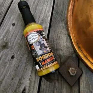 Hot sauce Voodoo Mango - fruktig, het och exotisk karibisk het sås - perfekt till tacos, grytor, räkor, gris och kyckling Hot sauce Voodoo Mango från Angus & Oink är en magiskt fruktig sås inspirerad av karibiska övärlden och Västindien - wow! Denna hot sauce passar perfekt till gris, kyckling och skaldjur. Tänk dig en grillkväll i solnedgång där en mixed grill med både kyckling, gris och skaldjur står redo att halstras över glöden. Exakt då behöver du denna sås! En bomb av fruktiga toner av mogen mango, het chili och örter man förknippar med karibiska övärlden.