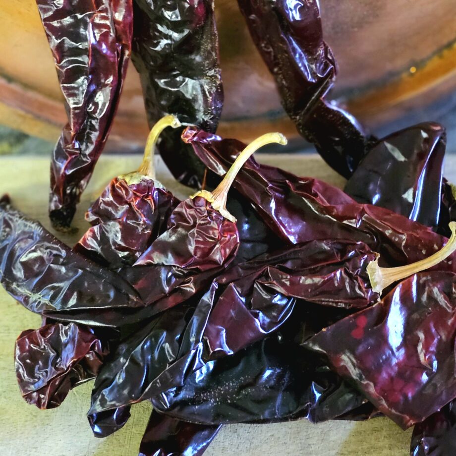 Guajillo chili 75 gram - torkad chilifrukt med toner av tranbär Guajillo är gjord på en chilisort vid namn Mirasol vilken fått torka. Skalet är tunt, blankt och smidigt som ett bättre skinn. Många anser att Guajillo är den jämte Ancho chili mest användbara torkade chilisorten. Den är enligt medelsvensson en mild Chili när det gäller styrkan (upp till 5000 Scoville). Smaken är delvis söt men också på gränsen till lite syrlig, tranbär är en bra liknelse (jämför då med Ancho som mer påminner om söta russin eller korinter). Koka den i vatten tillsammans med Ancho, Pasilla, chipotle och kanske en buljongtärning och lite muscvado socker, och låt den puttra en kvart. Mixa därefter med stavmixer och du har grunden för en Beef chili Taco gryta eller en BBQ - sås Observera: BBQmonster köper in stora partier av torkad chili och det händer då och då att de hinner gå ut i datum MEN var inte orolig - det handlar inte om ett "sista förbrukningsdatum" (likt det finns på ex kött) - alla livsmedel måste datumstämplas med ett "bäst före datum" - även Himalaya saltblock som är lika gamla som jordklotet... Torkad chili som förvaras svalt och mörkt blir inte sämre på vare sig två månader eller två år om förvaringen är korrekt. När du fått hem din chili är förslaget att du flyttar över den i glasburk som placeras mörkt och ej över rumstemperatur. Nettovikt 75 gram (oftast runt 10 chilifrukter)