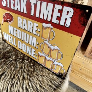 Tavla, plåtskylt "steak timer" Skylt vintage metall, tin sign metalltavla för kök, utekök, grillhörna, BBQ, Bar, Mancave Dekorera din favoritplats med tin signs - metalltavlor i rustik vintage design som bjuder in till ett skratt eller två ;) BBQmonster har en häftig samling plåtskyltar och tavlor i metall som kan vara den perfekta presenten eller tillbehöret till presenten som gör pricken över i:et, eller "the prick over the eye" som man säger i Amerikat... Metalltavlor för grill och BBQ är efterfrågade dekorer till utekök, mancaves och grillhörnor och med BBQmonsters uppsättning är chansen god att du hittar något som passar just dig eller den person du skall köpa presenten till. Livsnjutare, Foodies och grillare är ofta glada för både god mat och god dryck. Därför kretsar många av dessa metalltavlor på tema Mat, såsom recepttavlor (för exempelvis Pulled pork, Revben / Ribs och Brisket). Eller Dryck (whisky, bourbon, beer, öl, IPA, Cider, Stout och inte minst modedrycken GIN). Tavlorna i metall finns i ett antal olika format, men där det vanligaste är måtten 20 x 30 (stående) cm eller 30 x 20 (liggande). Det finns även ett par större modeller (bland annat runda). Tavlorna har en vikt kant så inga vassa kanter existerar. Hörnen är försedda med hål (på det fyrkantiga tavlorna) där du enkelt med två eller fyra spik eller skruvar fäster upp tavlan på underlaget. Du kan även använda dubbelhäftande tejp om det passar bättre mot underlaget. Du hittar alla tavlor under kategorin Tavlor metall 