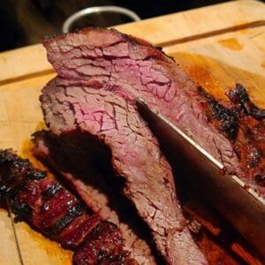 Vad är Flap-Meat: Flap är INTE Flank. Flap är en platt köttbit, i tjocklek med en flankstek men oftast något längre. Biten är placerad i anslutning med flanken men det är en muskel som inte har jobbat lika statiskt som flanken (som är muskeln som håller in buken). Detta gör att köttet är mycket mindre stumt än flankstek, mer som ett dragspel. Mjukt kött, "fluffigt" trots grova muskelfiber. Eftersom att det är en muskel som mest har "hängt med" och inte belastats tungt så pratar vi om en muskel som i det närmsta saknar stödvävnad och brosk. Vilket innebär att low & slow inte krävs, snarare tvärt om - köttet skall "bli klart" - ju snabbare och hetare desto bättre. Så här grillar du Flap: Gör grillen redo för riktigt het grillning. Rubba exempelvis med Black and white with a sting från #RubsByBBQmonster. Grilla hot & fast över het kol. Passa köttet noga, vänd när fettet börjar brinna eller när du ser att det svettas igenom. Lyft upp köttet från gallret och mät i c/c genom att dra en snabbtermometer sakta genom köttet. Våga köra det upp mot 70 grader i c/c och låt det få en hårt grillad yta. Köttet skärs lämpligen i 1 cm tjocka skivor. Var noga att skära tvärs över muskelfibrerna och inte längs med dessa. Formatet på köttbiten är oftast att likna vid Sverigekartan, så lägg köttet från "Norr till söder" med Skåne närmst dig, skär sedan köttet från Norr till Söder, alltså långa skivor. Du skär nu AV dessa fibrer, ej längs med. Genom att lägga kniven på diagonalen får du lite större skivor. Tips: Är kolen lite lam? För att få upp värmen ytterligare kan du med fördel slänga på lite torrt rökträ, testa ek eller hickory. Detta ger mer direkt hetta än glödande kol och tillför dessutom nya smaker och nyanser.