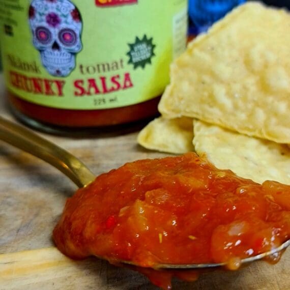 Chunky salsa - Tomat Habanero - perfekt till tortillas och tacos - Ekologisk Skånsk Chili Chunky salsa med rötterna i Skånska myllan, närmare bestämt i världsmetropolen Asmundtorp, känn på den världen! Denna Chunky salsa med smak av fruktig Habanero görs på deras egenodlade och obesprutade chilis, även koriandern är egenodlad. Tomaterna kommer från Skåne. Produktionen sker utan konserveringsmedel men tack vare en värmebehandling är hållbarheten mycket god. Chunky salsa Tomat Habanero är fint röd i färgen och ger ett mycket fruktigt svar när den landar på tungan. Chilistinget är medelstarkt (vi pratar trots allt om habanero) och värmer fint samtidigt som den underbara höga fruktigheten från habanero smörjer tungan med ett djup som nästa påminner om mogen banan. Koriander, lime. äpple och en lätt sälta kompletterar den fina sötman som kommer från ananas - och därmed har vi en välsmakande, het, chunky salsa som inte lämnar någon smaklök oberörd. Använd denna Chunky salsa tomat habanero som dip till tortillachips eller sleva ut den över dina tacos - go loco! 225 ml