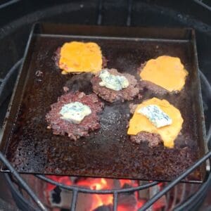 Stekbord / BBQmonster - 5,5 kg kolstål perfekt för smash burgers - för 47cm grillar / kamados och uppåt Detta stekbord i kolstål passar perfekt i Kamados och grillar i storlek 47cm och uppåt. Storleken gör att det kan cirkulera tillräckligt med luft runt och lämpar sig även för klassiska klotgrillar (likt 57:an). Lägg till BBQmonsters rostfria Smasher och du har ett smash burger kit som kommer ge dig många goa smashade burgare! BBQMonster tröttnade på upputsade (för hur länge är ett stekbord skinande rent?) och snuskigt dyra stekbord och kontaktade ett lokalt företag och bad om ett stekbord i kolstål som levde upp till följande kriterier: Kolstål - för bästa värmeledningsförmåga Maximerad storlek för en 47cm kamado (kamado joe classic, BGE large mfl) Kraftigt stål för att kunna få vätska att avdunsta snabbt Kanter på tre av sidorna för att fånga fett och underlätta flippandet En inbränd logo för att visa var det kommer ifrån Ut från "smen" kom ett hundratal produkter och där stekbordet i sig vägde in sig på en stabil matchvikt runt 5.5kg och måtten 34cm x 32 cm med en 4cm hög kant och ett gods som är 6mm tjockt. More is more Ju grövre gods desto mer energi kan lagras i metallen. När du lägger på en bit kött kommer energi (värme) stjälas från godset. Är godset för tunt blir det snabbt kallt och du får inte den önskade karamelliserade ytan utan köttets yta blir snarare lätt kokt under en kort tid. Grovt kolstål likt detta kan ackumulera mycket värme och ger ett högre värmeanslag mot livsmedlet detta oavsett om vi pratar om ett stekbord eller stekpanna i gjutjärn. Smash burgers Smashburgers är inte längre en trend utan är numera standard för att göra fina burgare på bra färs. För att lyckas med en fin smashad burgare så behöver du bra färs, gärna av högrev, gärna av grainfed blackangus, och en fetthalt som närmar sig 20% (det finns såklart i butiken ;)). Därefter behöver du en värmekälla som ger dig runt 300 grader (BBQMonster rekommenderar kolen av Björk/EK) samt ett stekbord likt detta. Salta och peppra färsen när du försiktigt lagt ut den som en två cm tjock matta. Tryck med dina rena (!) fingertoppar ner salt och svartpeppar i färsen, detta utan att förstöra "köttsträngarna". Forma ut bollar i en vikt som motsvarar den storlek du önskar på burgarna, många gör hellre fler små burgare än en feting (då får man mer av den goda smått brända utsidan!). Låt stekbordet vara med över kolen redan från början när du tänder, då blir det ordentligt uppvärmt och du minskar risken för att stålet slår sig. När tempen passerar 300 grader så tar du fram dina bollar (rätt bollar) och lägger dem på stekbordet. Börja med en, när det fräst och bubblat ut lite fett från bollen så tar du fram din "smasher" och ger köttet ett jämnt och lagom hårt tryck för att pressa ut köttbollen till en burgare i den tjocklek du önskar. Lägg på nästa boll och pressa ut den, repetera. Eftersom att du har köpt en väldigt bra färs så kommer burgaren att gå att vända väldigt enkelt med hjälp av en klassisk turner. Vänd burgarna i samma ordning som du la på dem på stekbordet. Grattis - du har nu smashat dina första burgare och du kommer aldrig återgå till någon annan tillagningsform.