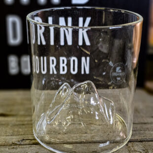 Bourbonglas BBQmonster - "On the Rock" - Tumblerglas med ett stegrande berg inuti glaset - effektfullt BBQmonsters egna "on the rock" Bourbon och Whiskey Tumblerglas gör ingen besviken. Grymt snyggt bourbon glas med ett stegrande berg på insidan inuti glaset. En perfekt present till dig själv eller någon som uppskattar bourbon och whiskey. Tublerglas av denna stil är ett klassiskt glas för Bourbon, American Whiskey, Tennesse Whiskey och Kentucky Straight bourbon. Samtliga varianter av whiskey drickes med fördel i denna typ av Bourbonglas. BBQmonster "on the rock" Bourbonglas är av genomklart glas, vilket framhåller och låter dryckens nyanser lysa igenom, samtidigt som bergen inuti glaset låter ljus och skuggor reflekteras på ett stilfullt sätt. Glaset rymmer 35cl och är 9 cm högt samt 8 cm i diameter Glaset bör diskas för hand för att undvika jordbävning (Berget gör det något känsligare mot kraftfulla stötar) BBQmonster berättar: Vad är skillnaden på Whisky, Whiskey och Bourbon? Whisky, whiskey eller bourbon - det finns såklart böcker skrivna på ämnet men lite grundtankar som du kan ta med dig när du pratar och diskuterar "whiskey". Whiskey med "ey" på slutet pekar oftast på att whiskeyn är från andra sidan atlanten - USA, Kanada. Bourbon är en gren av Whiskey trädet. För att en whiskey skall få kallas "Bourbon" ska den bland annat uppfylla att minst 51% av malten bestått av majs. Resten kan komma från korn, vete eller råg, endera eller som en mix. Inga färgämne får användas och det skall ha lagrats på nya kolade fat av amerikansk ek. Det sistnämnda tillför den klassiska doften och smaken av vanilj. Om en Bourbon har lagrat på fat mer än två år får den kallas för "Straight Bourbon". Bourbon är oftast en mild bekantskap oavsett från vilket område den kommer men testa dig fram, det skiljer mycket och inte minst i sötman. Många uppskattar Bourbon och Whiskey bättre när drycken serveras över isbitar som sänker tempen och får sötman att jämna ut sig - testa!