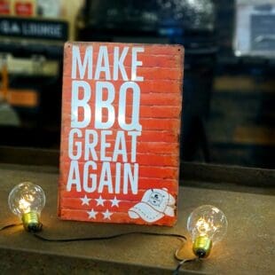 Plåtskylt för kök mm. "Make BBQ great again" Skylt för kök, utekök, grillhörna, BBQ, Bar, Mancave Dekorera din favoritplats med skyltar och metalltavlor i rustik vintage design som bjuder in till ett skratt eller två ;) Här plåtskylten som förkunnar det som vi alla vet måste komma - Make BBQ great again. Tavlor i metall och plåtskyltar? BBQmonster har en häftig samling tavlor och skyltar i metall som kan vara den perfekta presenten eller tillbehöret till presenten som gör pricken över i:et, eller "the prick over the eye" som man säger i Amerikat... Metalltavlor för grill och BBQ är efterfrågade dekorer till utekök, mancaves och grillhörnor och med BBQmonsters uppsättning är chansen god att du hittar en skylt som passar just dig eller den person du skall köpa presenten till. Ett presenttips kan vara att om du köper låt säga ett paket spanska ginglas att då komplettera med en skylt som förstärker budskapet. Samma sak kan appliceras Ölglas, Kamados osv. Livsnjutare, Foodies och grillare är ofta glada för både god mat och god dryck. Därför kretsar många av dessa vintage skyltar och metalltavlor på tema Mat, såsom recepttavlor (för exempelvis Pulled pork, Revben / Ribs och Brisket). Eller Dryck (whisky, bourbon, beer, öl, IPA, Cider, Stout och inte minst modedrycken GIN). Tavlorna i metall finns i ett antal olika format, men där det vanligaste är måtten 20 x 30 (stående) cm eller 30 x 20 (liggande). Det finns även ett par större modeller (bland annat runda). Skyltarna har en vikt kant så inga vassa kanter existerar. Hörnen är försedda med hål (på det fyrkantiga tavlorna) där du enkelt med två eller fyra spik eller skruvar fäster upp tavlan på underlaget. Du kan även använda dubbelhäftande tejp om det passar bättre mot underlaget. Du hittar alla tavlor och skyltar under kategorin Tavlor metall (www.bbqmonster.se/produkt-kategori/tavlor/)