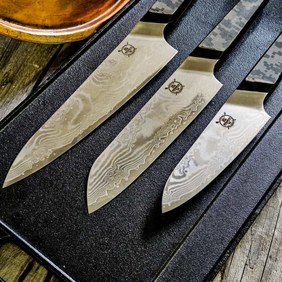 Kockknivs set "Camo" - tre knviar från BBQmonsters finaste knivserie. Rakbladsvassa blad med vackert damaskus mönster och coolt digi-camo-handtag Här har du det ultimata knivsetet, ett set med tre olika kockknivar som täcker alla behov i köket. Camo36 #1 En klassisk kockkniv som fungerar till allt i köket, både kött och grönsaker, detta då knivbladet är hela 27cm långt och precis som övriga knivar i denna serie - galet vassa! Camo31 #2 En santoku-kniv är något kortare än en klassisk kockkniv och har ett mer rundat avslut av eggen ovansida. Många använder santokuknivar till att skära upp och hacka grönsaker men kniven fungerar utmärkt även för kött. Camo27 #3 En Petty-kniv ("skalkniv") är betydligt kortare en klassisk kockkniv och något kortare än en Santoku-kniv Många använder Pettyknivar till finlir i köket och för att skära upp mindre grönsaker men kniven fungerar utmärkt även för att putsa kött. Introduktionspris - passa på! Bladet är vackert damaskusmönstrat - som helhet en av de vackraste knivar som vi sett och definitivt den vassaste - totalt 100% "intstagramvänlig" och photogenique. Vi gjorde ett test (se clipet på vår Youtube-kanal) med den större kockkniven i samma serie: en liten plommontomat (ca 10 gram) släpptes från några decimeters höjd mot knivens egg och utan att studsa så skars tomaten i en fin skiva med endast tyngdlagens inverkan mot knivens egg - imponerande! Ibland kan man se liknande test men där man istället släpper något betydligt tyngre, som en mindre melon eller en banan...ett sådant test säger inte allt för mycket, men vårt test berättar att denna kniv skall behandlas med största försiktighet. Detta kockkniv set med kockknivar är en perfekt present, julklapp eller farsdagspresent till dig själv eller någon annan som uppskattar matlagning. Knivarna levereras var och en i en svart presentbox med BBQmonsters logo och sigill. Total längd: 36cm / 31cm /27cm  Längd på bladet: 28cm / 18cm / 14 cm Längd på skaftet: 13 cm Vi rekommenderar att du använder våra smidiga skyddshandskar när du använder dessa knivar