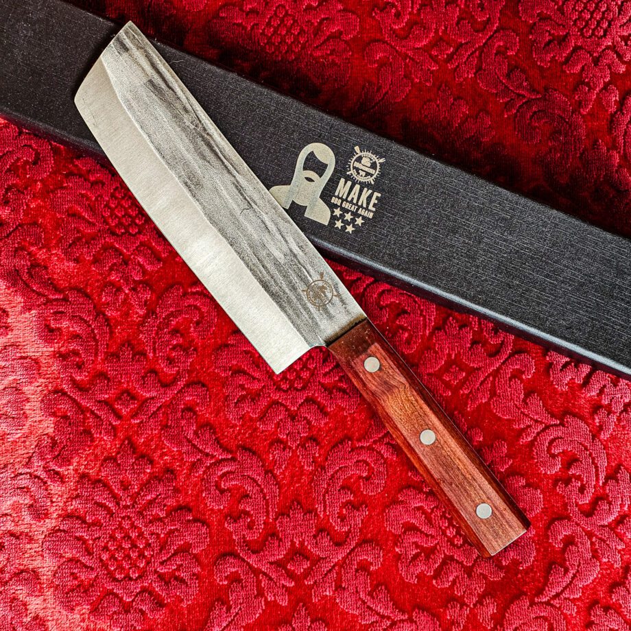 Nakiri Kockkniv Red Velvet #15 vacker kniv från BBQmonsters serie av Asiatiska kockknivar - liknande kniv säljs för det tredubbla på andra sidor! Söker du en serie av välarbetade och lättskötta kockknivar? Ta en kik på BBQmonsters egna serie knivar! Samtliga knivar i serien kommer i en svart presentförpackning med BBQmonsters sigill "Make BBQ great again" tryckt på locket. Knivarna från BBQmonster har även BBQmonsters logo ingraverad på bladet. Vi sätter bara vår logo på prylar som vi verkligen tycker om - detta är en sådan. Introduktionspris - passa på! En perfekt till grillnörden, en present till pappa på farsdag eller till dig själv helt enkelt! Nakiri kockkniven i serien Red velvet har ett abrupt avslut av bladet, nästan likt en avbruten kniv. Bladets höjd är sett till bladet längd relativt högt. Detta gör att du här har en lättstyrd kniv som du med enkelhet kan hacka upp stora mängder grönsaker i symmetriska former  . Kniven har en längd som gör den enkel att kontrollera om du önskar använda den för att dekorera en frukt eller grönsak med ett snyggt inristat mönster. En bra allround grönsakskniv som ersätter en klassisk "petty-kniv". Bladet på denna Red Velvet #15 är vackert dekorerat med mjuka följsamma mönster inhamrat i stålet. Bladet har en perfekt balans mellan smidigt och robust. Eggen är extremt vass och lättskött. Varje blad är unikt i sitt utseende vilket tillsammans allts som allt gör detta kniven rejält "intstagramvänlig" och photogenique. Bladet är genomgående och avslutas med det snygga fyrkantiga handtaget som är av rött ädelträ och som har tre nitar av mässing. Skaftet ger ett skönt grepp och är enkelt att rengöra. Handtaget passar både höger- och vänsterhänta. Kolstål med blandning X50CrMoV15 Hårdhet 56° HRC vilket är ett relativt mjukt stål - något som gör att du själv enkelt kan hålla din kniv vass. Total längd: 31 cm Längd på bladet: 18 cm Längd på skaftet: 13cm Vikt: 276 gram