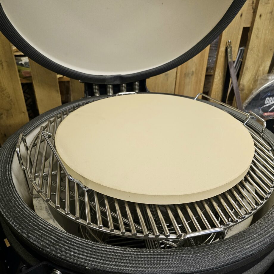 Pizzasten - 38cm i diameter Hela 2cm tjock (33% tjockare än de flesta andra) = bättre värmefördelning Inkluderar en hållare (handtag) i metall för enklare hantering av en varm sten Pizza på pizzasten är hemligheten till en "köp-pizza-känsla" där degen är krispig och genombakad utan att blivit som ett knäckebröd. Denna pizzasten är gjord av högkvalitativ värmetålig keramik. Passar både i klotgrillar (som weber 57), gasolgrillar, ugnar och såklart kamado såsom kamado Joe, bastard kamado, Big green egg, sumo mfl. Denna pizzasten har en diameter på 38 cm, vilket är en alldeles lagom storlek på en pizzza - större och det blir svårt att göra annat än Calzone... Pizzastenen är hela 2cm tjock vilket är ungefär 33% tjockare än de flesta pizzastenar och tjockleken är inte oviktig - tjockare sten ger en bättre värmefördelning och mindre risk för en bränd pizzabotten. Många är vi som på början av 2000 talet letade efter det perfekta receptet på pizzadeg i tron att detta var skillnaden som gjorde skillnaden - vi hade FEL. Hemligheten till en bra bakad pizza ligger istället i att degen bakas under ifrån, från ett redan hett underlag - alltså en upphettad pizzasten. Lagom temperatur i grillen (eller ugnen) är 280 till 350 grader. För många är det då grillen som gäller, då de flesta hushållsugnar stannar på runt 225grader. Tekniken är: varm upp stenen, kavla ut degen på ett bakplåtspapper, dressa din pizza med dina favoriter men börja alltid med tomatsåsen, därefter pizzaosten, sen är det valfritt. Lyft över pizzan på sitt papper, låt den landa på stenen och ganska snart kan du rycka bort pappret. Använd pizzaspade (artikel nr 31016) för att lyfta bort pizzan när osten bubblar. Diameter 38 cm Skydda tassarna med värmetåliga handskar